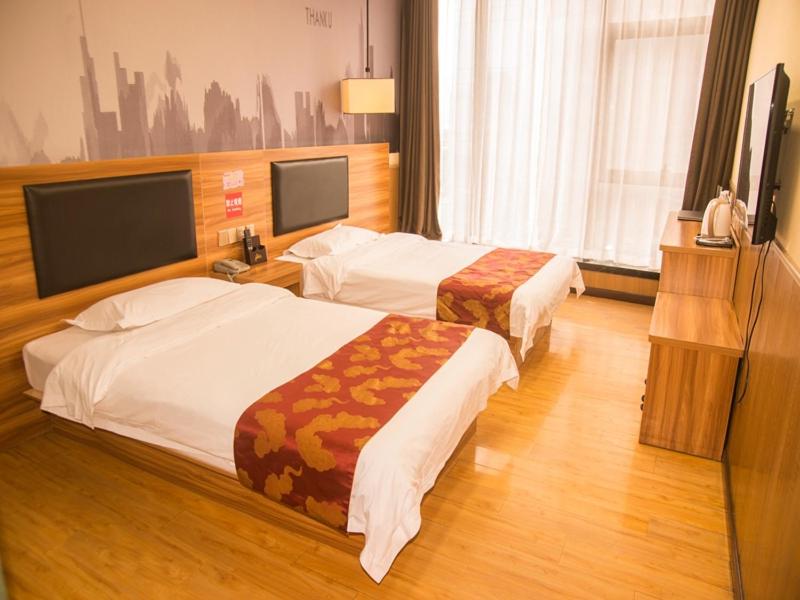 郑州尚客优酒店河南郑州郑东新区东站店的酒店客房设有两张床和一台平面电视。
