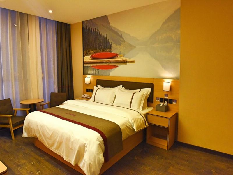 通道尚客优酒店湖南怀化通道县汽车站店的酒店客房设有一张床,墙上挂有绘画作品