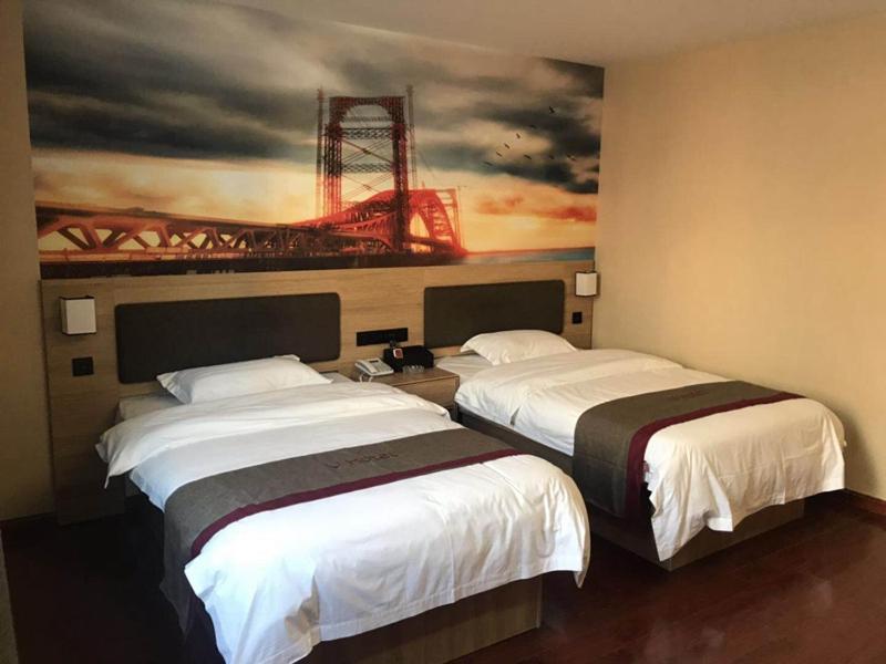 南京尚客优酒店江苏南京江宁区陶吴店的两张位于酒店客房的床,墙上挂着一幅画