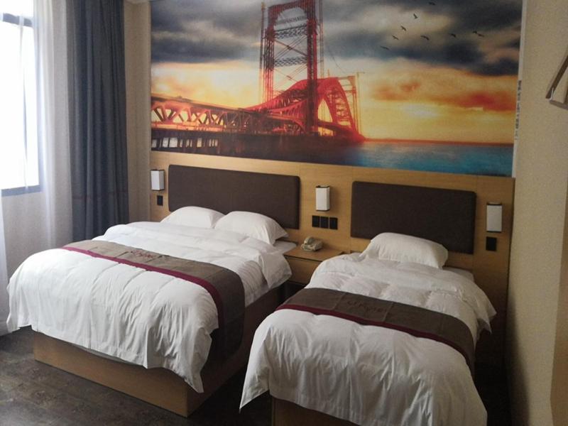 铜仁尚客优酒店贵州铜仁江口县梵净山公园凤凰路店的两张位于酒店客房的床,墙上挂着一幅画