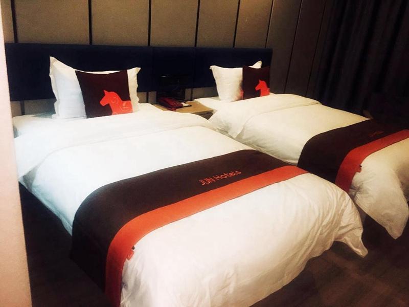 西宁骏怡连锁青海西宁城东区新千国际广场店的酒店客房设有三张床,上面有红色的十字架