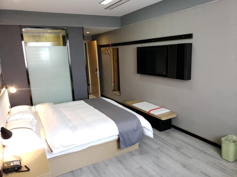 安庆尚客优酒店安徽安庆宜秀区政府大学城店的一间卧室配有一张床和一台平面电视