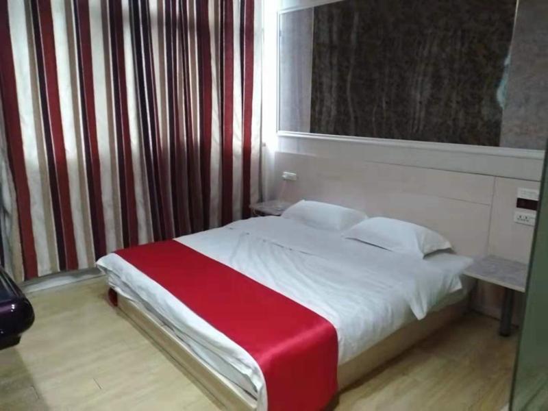 阜阳尚客优酒店安徽阜阳商贸城店的一间卧室配有一张带红色毯子的床