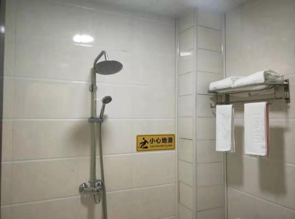 丽江尚客优酒店云南丽江古城区大水车北门店的带淋浴的浴室和墙上的标志