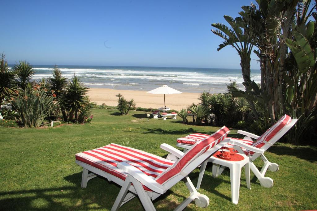 维德尼斯东街之家海滩旅馆的两张草坪椅和一张桌子,享有海滩美景