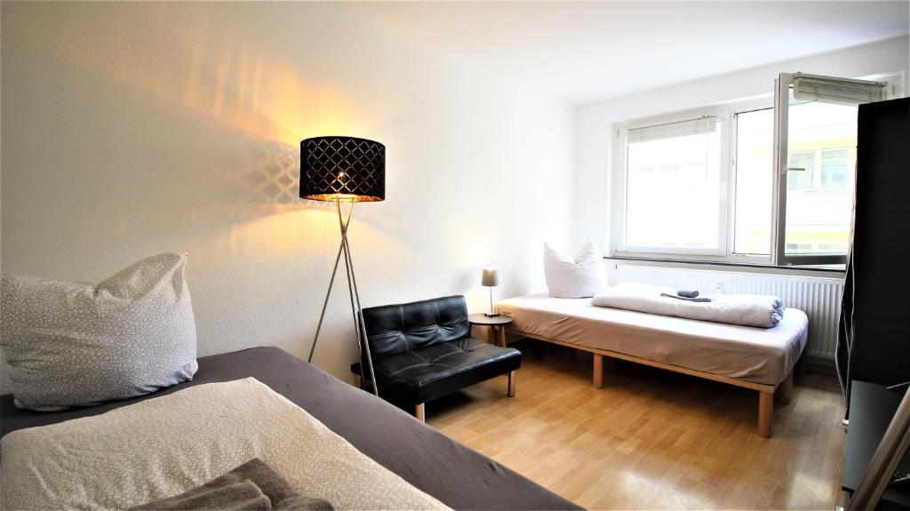 维尔茨堡Private Room-Vineyards and City的卧室配有床、椅子和窗户。