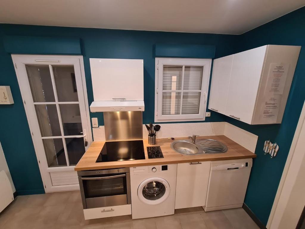 莱萨布勒-多洛讷Maison 2 Chambres Parking Linge de lit fourni的厨房配有白色橱柜和炉灶烤箱。