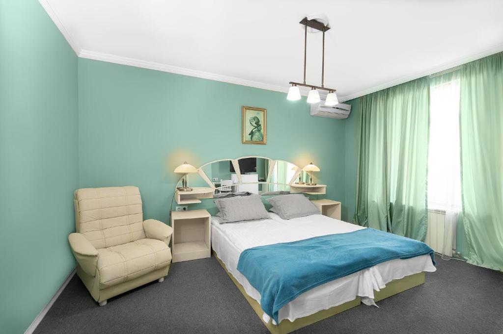 布尔加斯博瑞亚娜酒店的一间卧室配有一张床、一把椅子和镜子