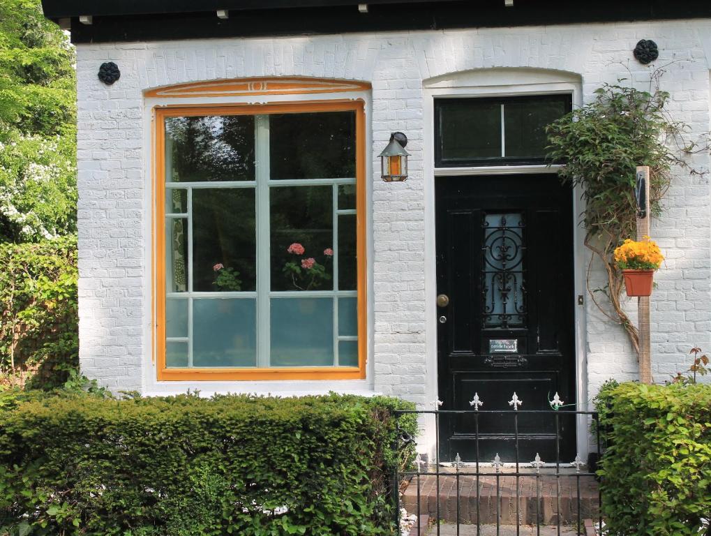 BakkeveenB&B Appartement De Winkeljuffer的白色房子上带窗户的黑色门