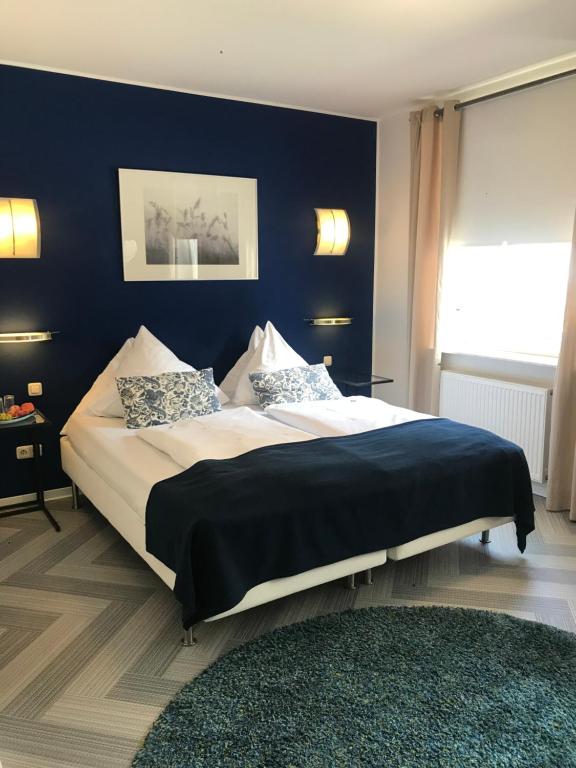 亚琛bensons hotel的一间卧室设有一张蓝色墙壁的大床