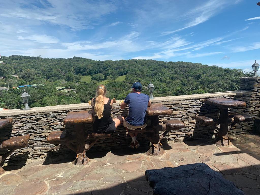 蒙泰韦尔德哥斯达黎加Cabinas Vista Al Golffo的坐在岩石墙上长凳上的男人和女人