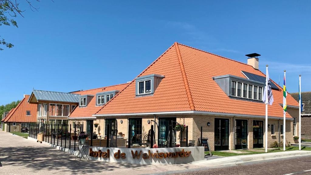 莱斯瓦尔维斯瓦尔德酒店的街道上一座有橙色屋顶的建筑