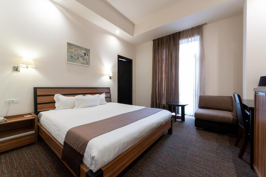 埃里温低音精品酒店 的配有一张床和一把椅子的酒店客房