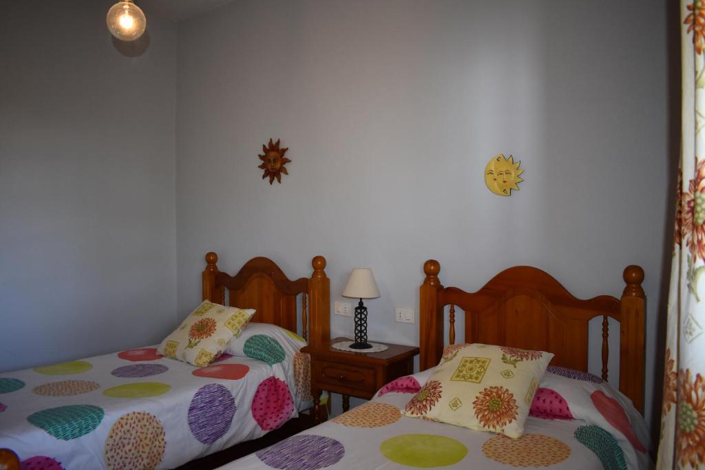 蒂哈拉费Casa Rosa的一间卧室配有两张单人床和一张带台灯的桌子