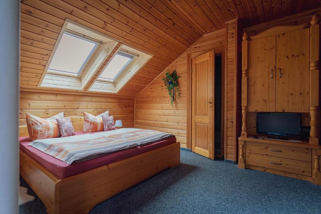 HundshübelGaststätte und Pension Zum Torfstich的小屋内设有一间带床铺和电视的卧室