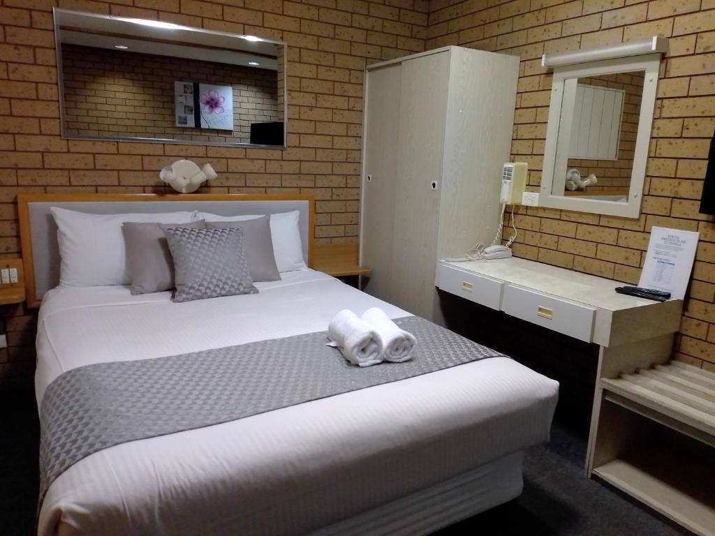 谢珀顿乡村之家汽车旅馆的卧室配有一张白色大床和镜子