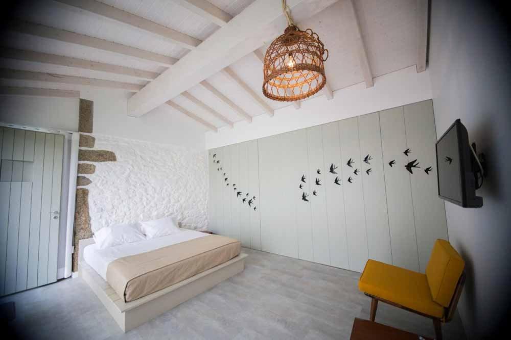 巴塞卢什Casa Lugar da Aldeia的卧室配有一张床,墙上有鸟儿