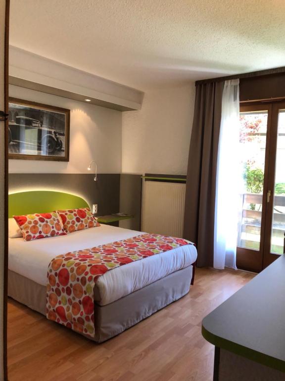 欧丹库尔Les Tilleuls Montbeliard Sud Audincourt的酒店客房设有床和窗户。