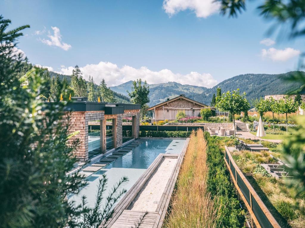 霍赫克尼希山麓丁滕优泊古森艾姆度假酒店的一座带游泳池和山脉的房屋