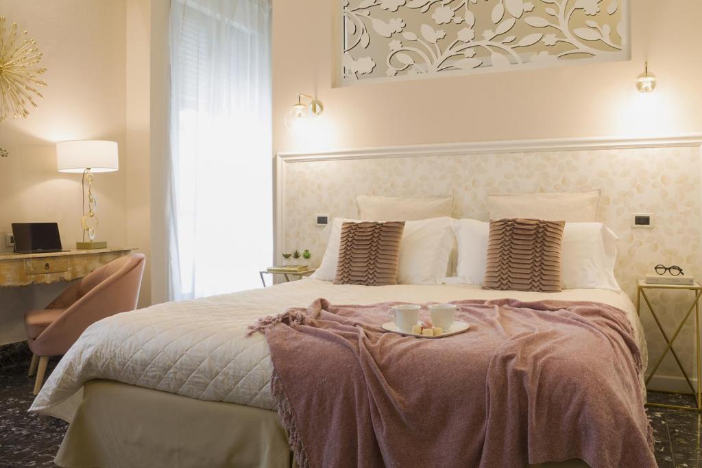 普拉托阿坎托阿尔中心住宿加早餐旅馆的一间卧室配有一张大床,上面有托盘
