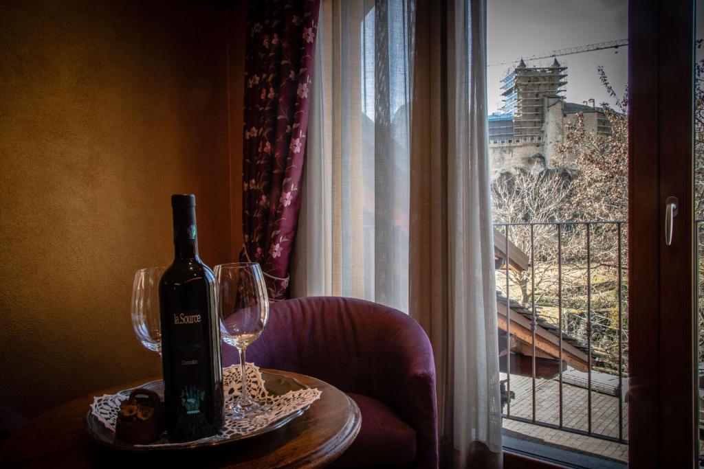 圣皮埃尔Wine-Farm La Source的坐在窗边桌子上的一瓶葡萄酒