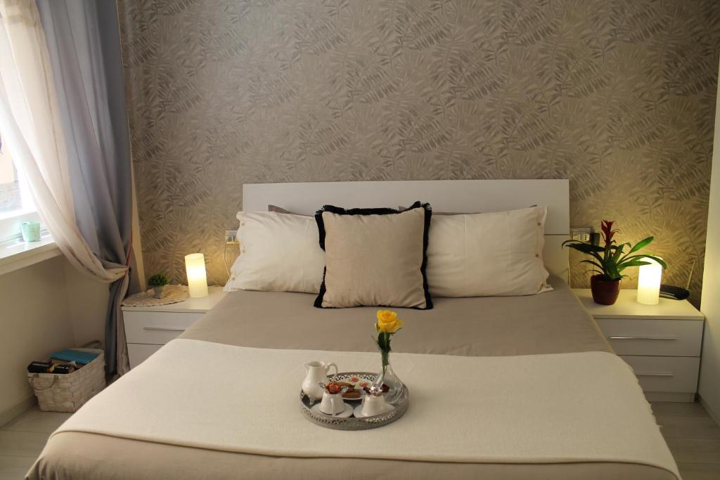 佛罗伦萨辛诺拉广场公寓的一间卧室,配有一张带花卉和蜡烛的床