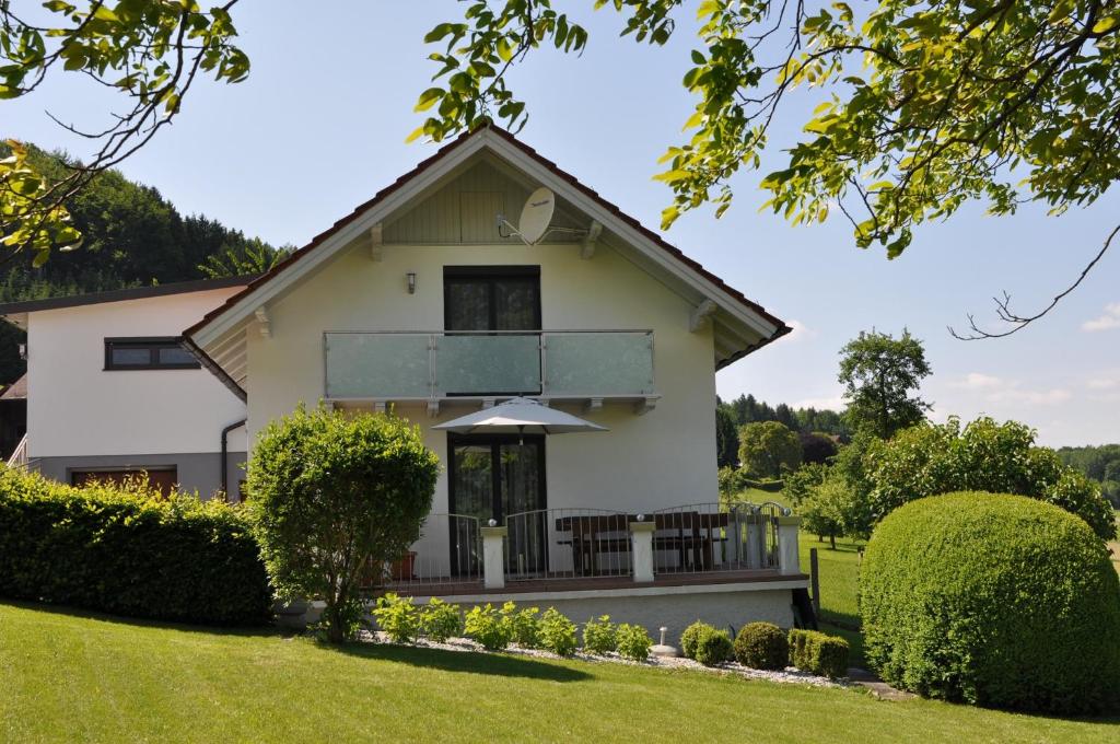 阿特湖Das Ferienhaus的绿色庭院的白色房子