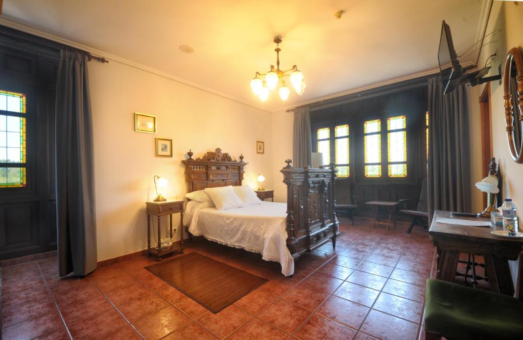 卡尔瓦略Hotel Mar de Queo的卧室配有床、桌子和窗户。