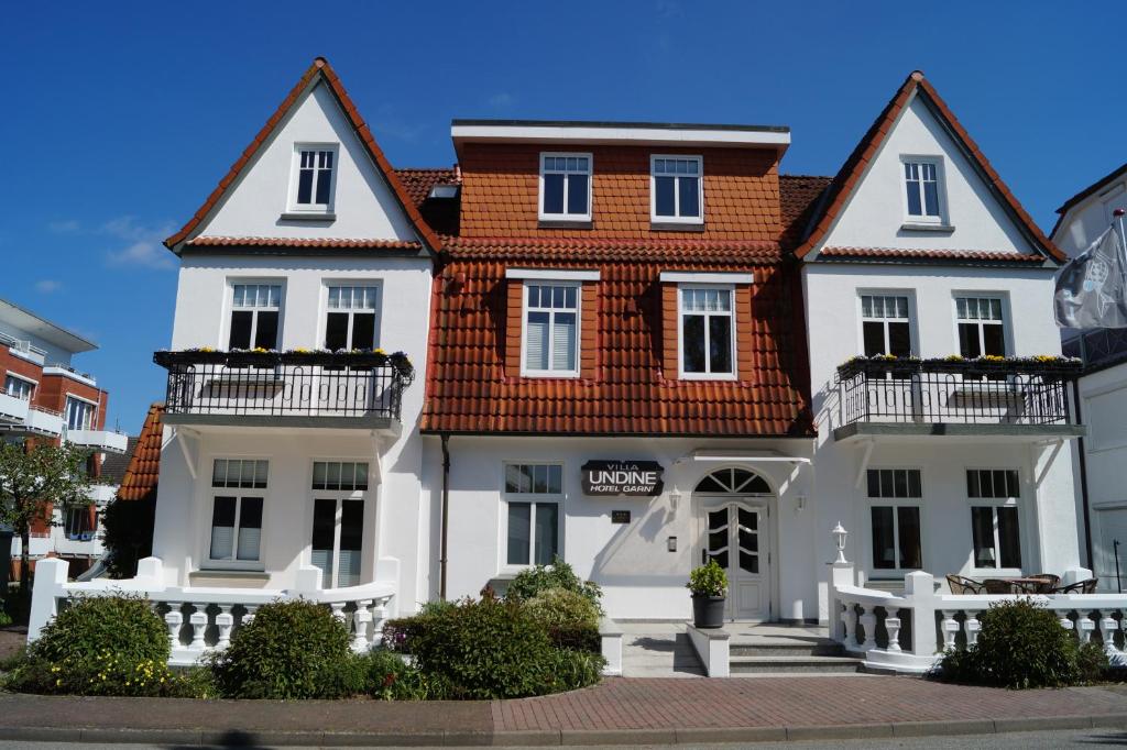 格洛米茨温蒂妮酒店的一座大型白色房屋,设有红色屋顶