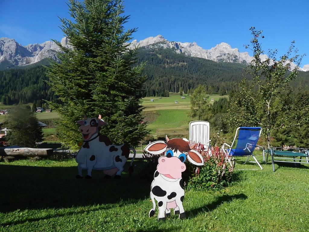 帕多拉Residence La Pineta的两头塑料牛和一头奶牛在草地上的雕像