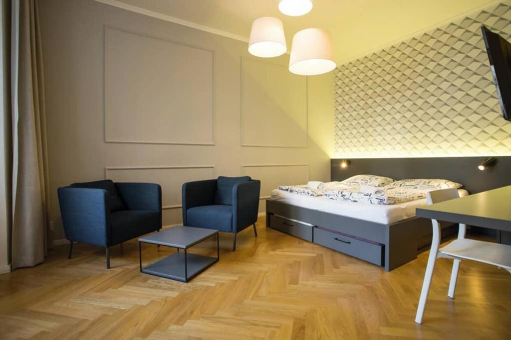 布拉格Design Studio Anděl, All Historical Sights Walkable的配有床和两把椅子及一张桌子的房间