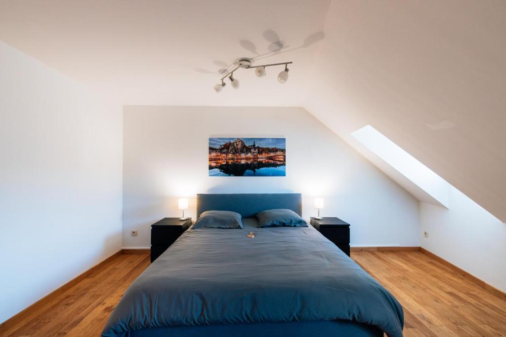 迪南Les rives de Sax的一间卧室配有蓝色的床和2个床头柜