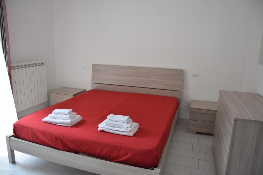 卡诺萨迪普利亚Casa di marco2的一间卧室配有红色的床和毛巾