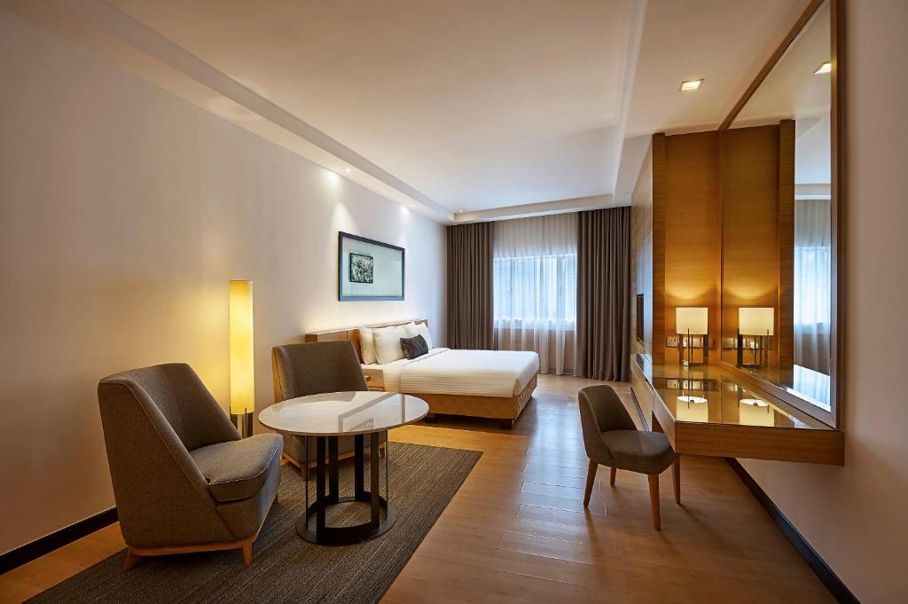 吉隆坡吉隆坡安莎酒店的酒店客房带一张床、一张桌子和椅子