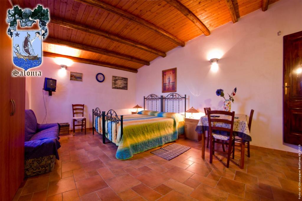卡萨马卡里Alle Riserve Vendicari的卧室配有一张床和一张桌子及椅子