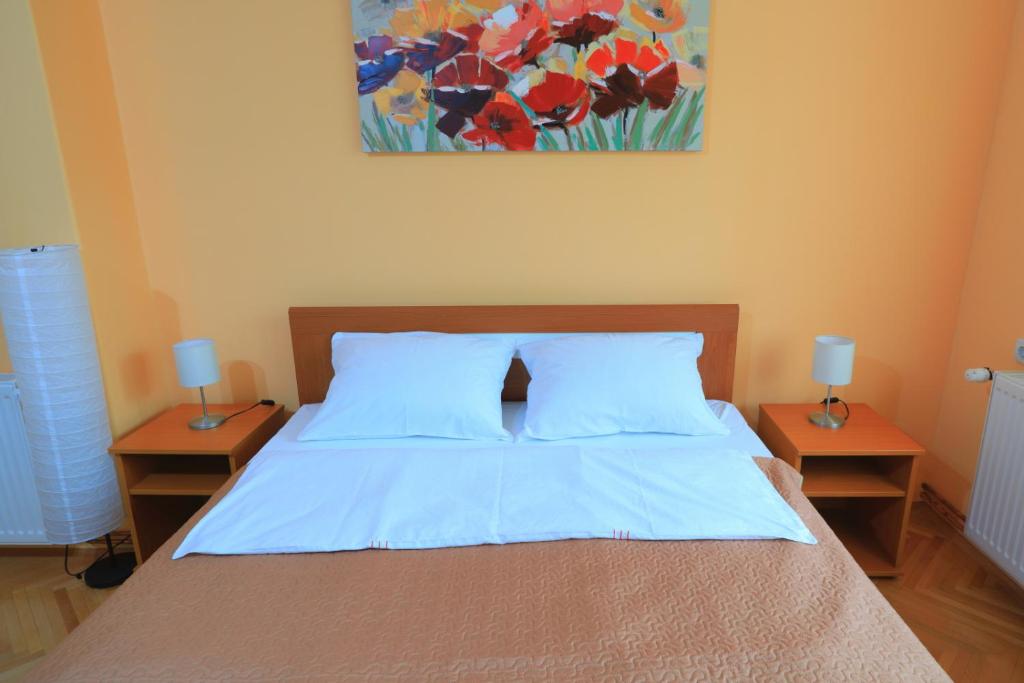 索科矿泉村Apartman Tina Sokobanja的一间卧室配有一张带两个床头柜和一幅画的床。