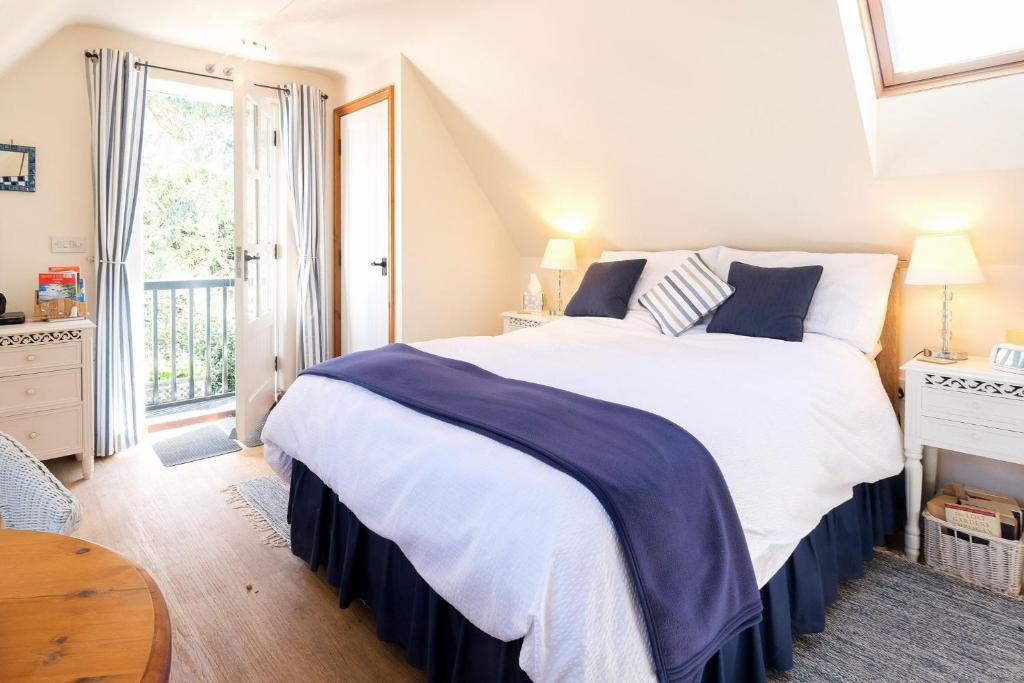索普尼斯The Bay Tree Studio的卧室设有一张白色大床和一扇窗户。