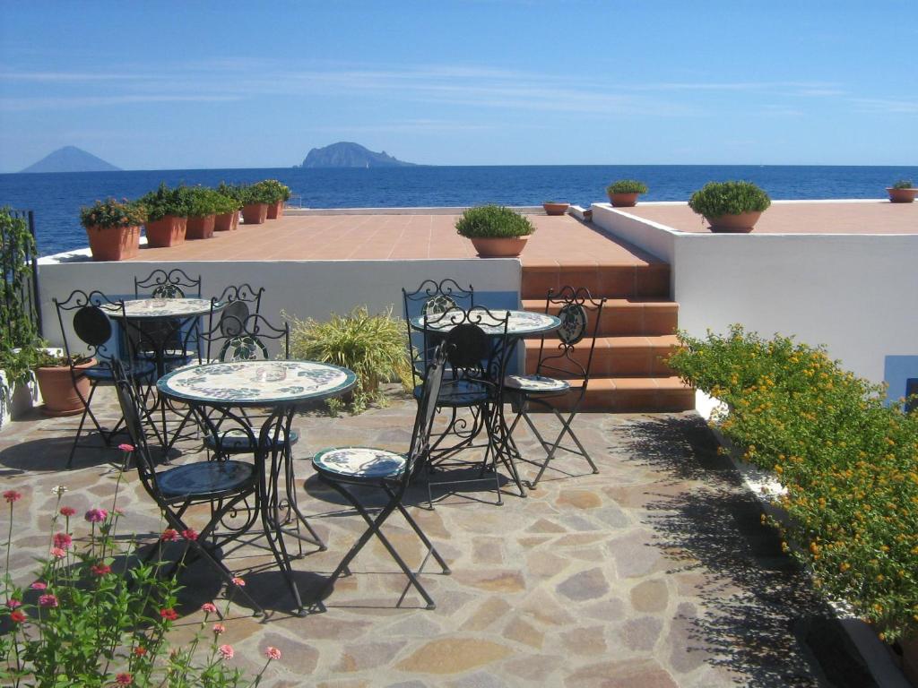 圣马里纳萨利纳蓬塔巴罗尼酒店的一个带桌椅的庭院和大海