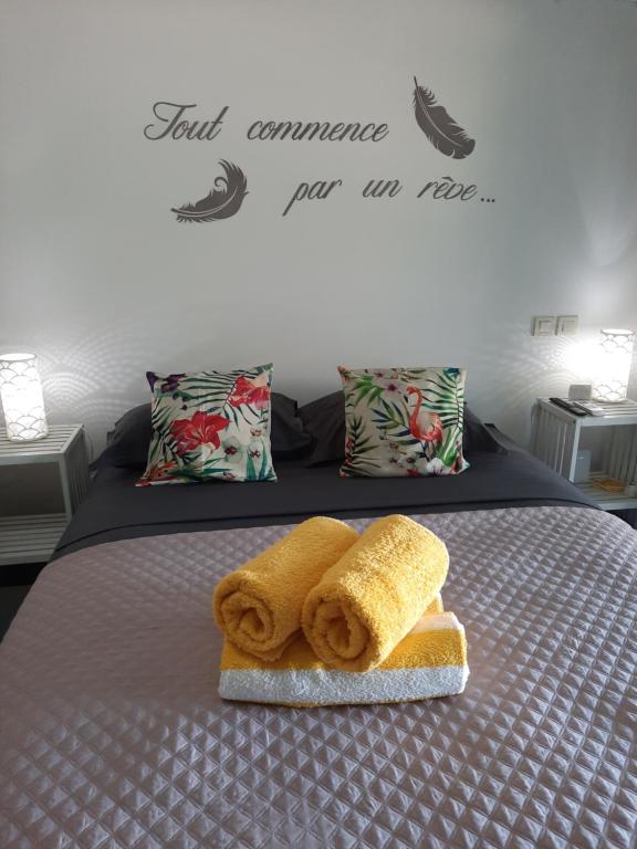 帕皮提Little home Tahiti的一张带两条毛巾和一块面包的床