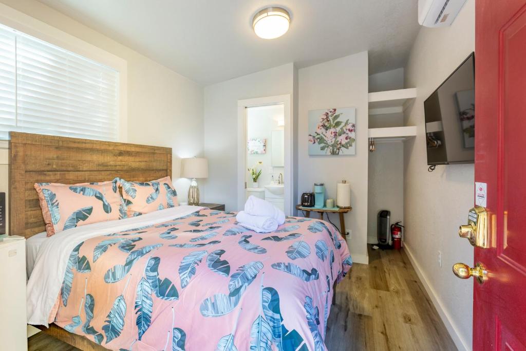 圣何塞@ Marbella Lane Mini Guest House in Downtown San Jose的一间卧室配有一张带粉红色和蓝色棉被的床