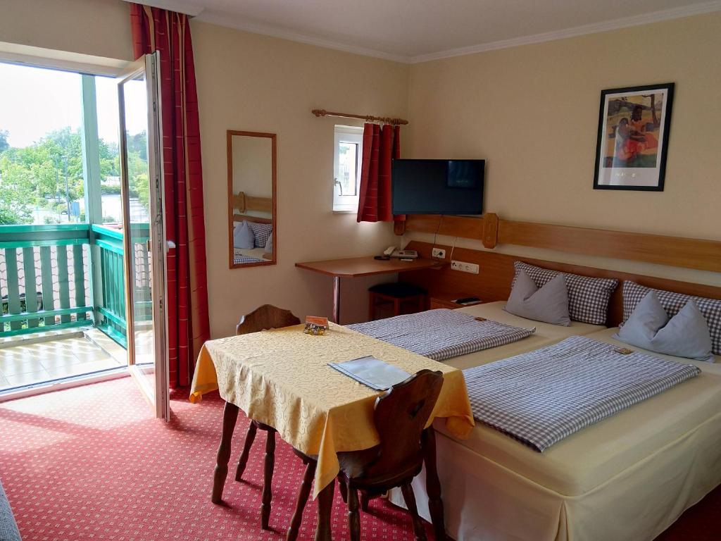 巴特乔京福耳图那公寓式酒店的一间带两张床和一张桌子的卧室以及一个阳台