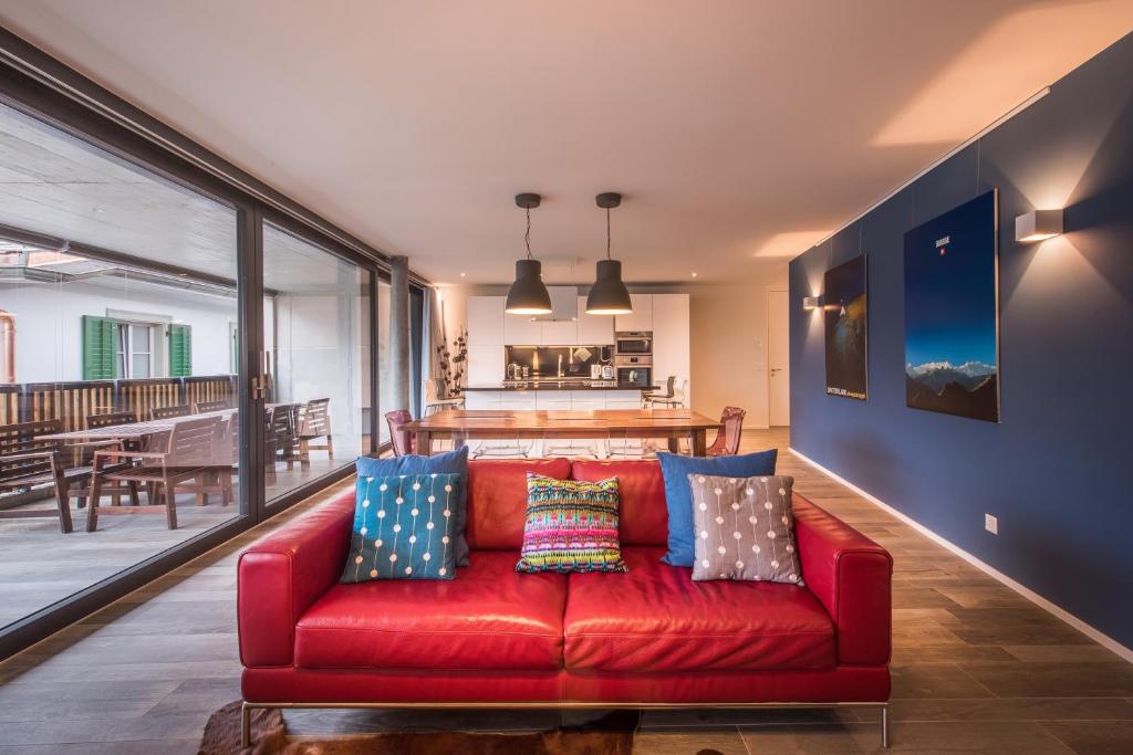 因特拉肯Independance Penthouse的客厅里配有红色沙发及枕头