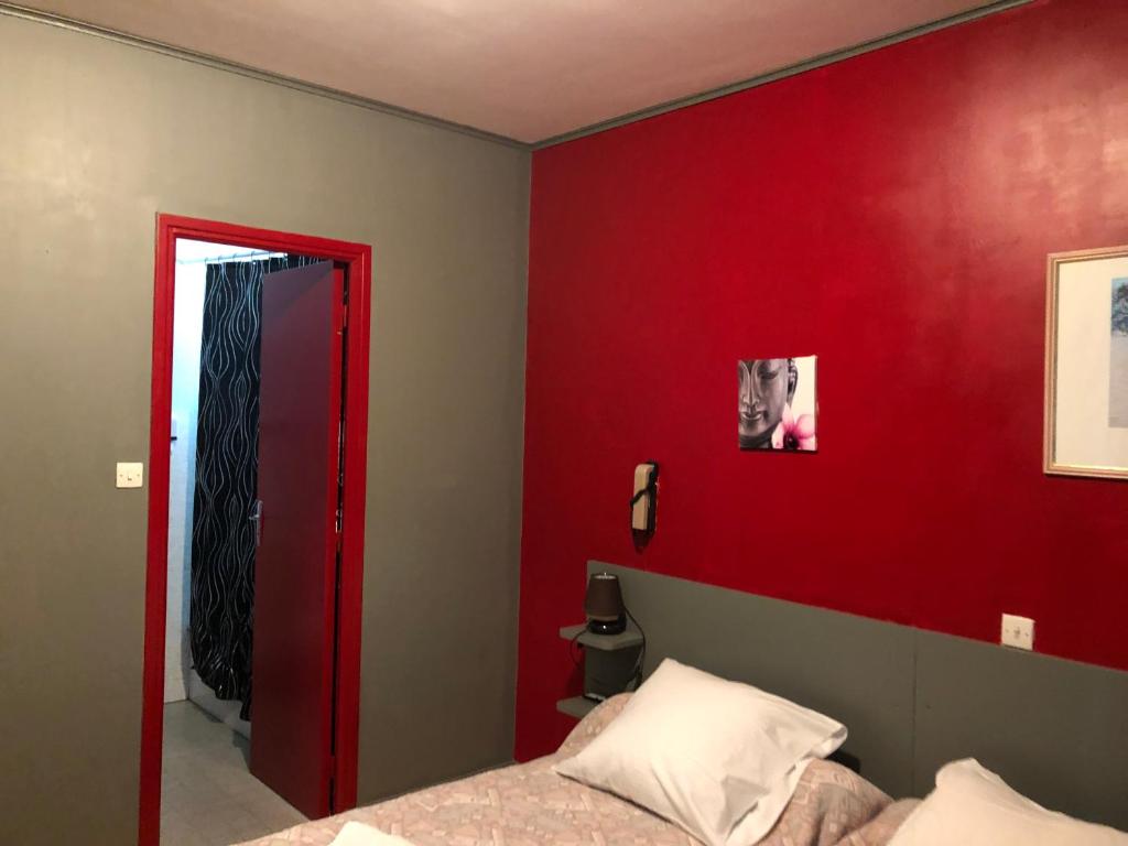 Saint Firmin拉特里尼特酒店的卧室设有红色的墙壁和一张床