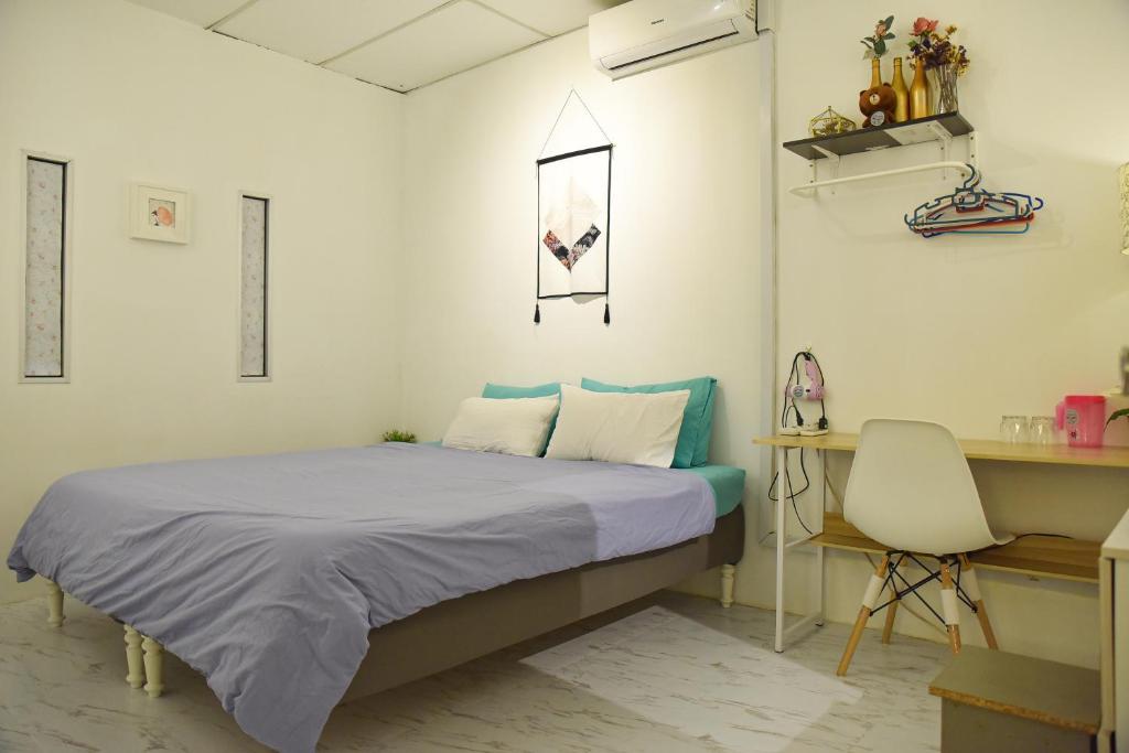 科塔达曼萨拉G Traveler Accommodation Homes 居旅舍的一间卧室配有一张床、一张桌子和一把椅子
