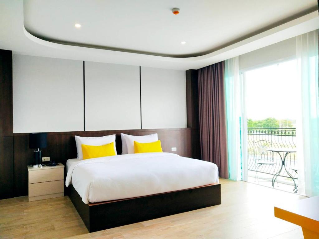 呵叻โคโค่ โฮเทล KOCO Hotel的一间卧室配有一张带黄色枕头的大床