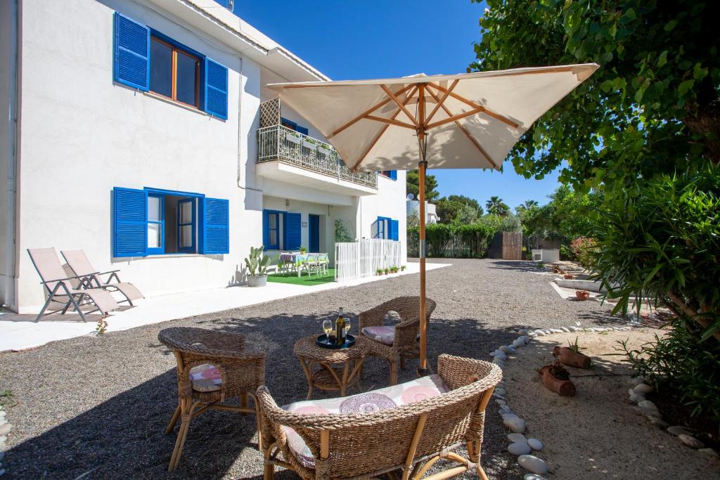 阿门多拉拉Don Bruno Homes的一个带桌子和遮阳伞的庭院