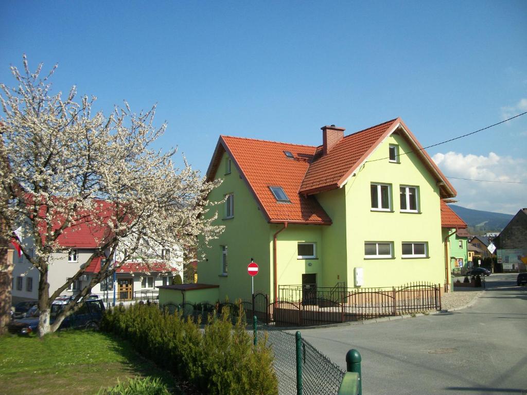 斯托尼拉斯奇Na Skwerku的黄色和绿色的房子,有红色屋顶