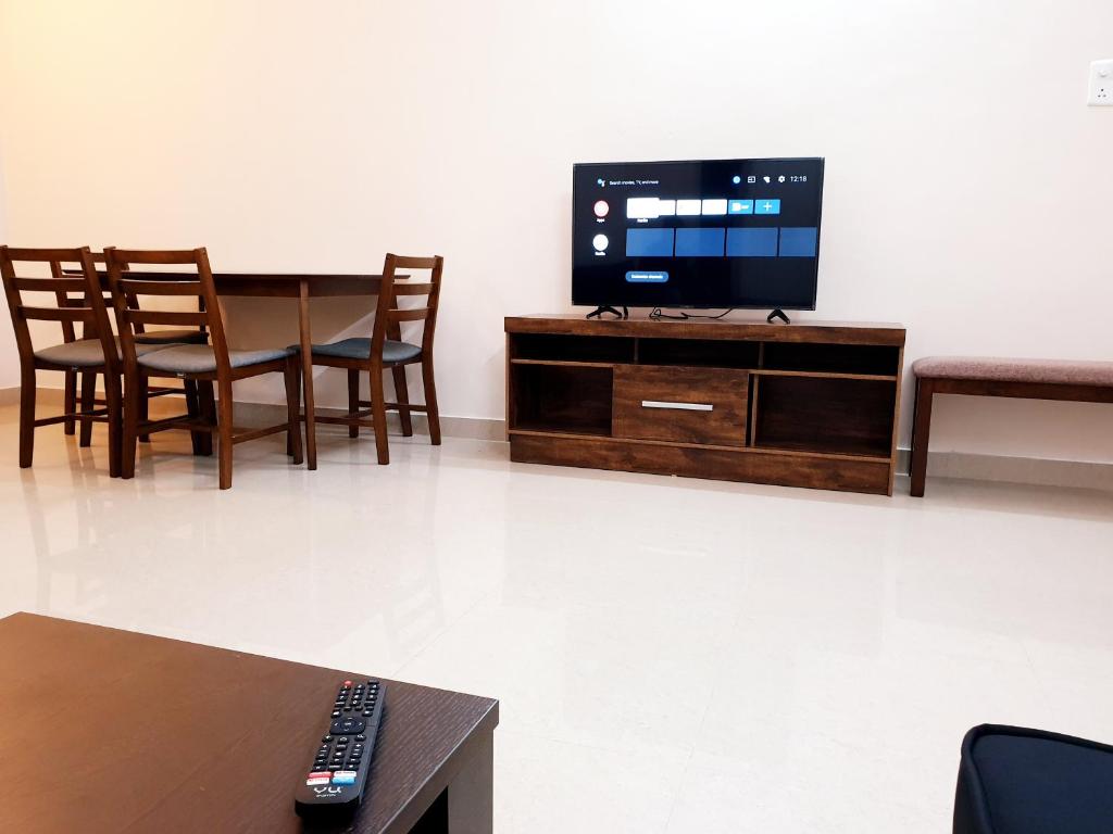 钦奈Chippy Apartments No23的客厅配有电视和桌椅