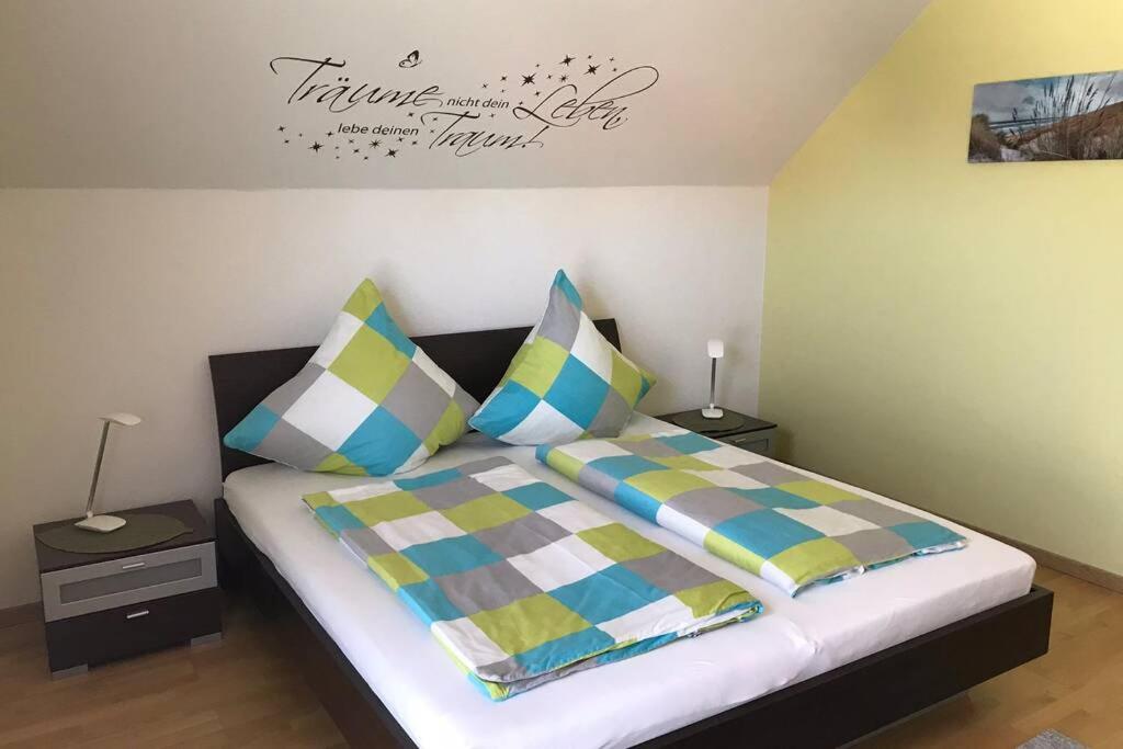 莱茵河畔韦尔特Ferienwohnung „Anhaide“的一间卧室配有带色彩缤纷枕头的床
