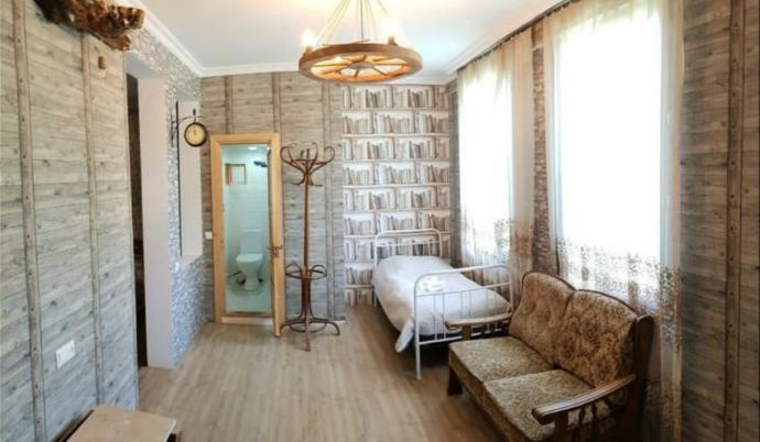 博尔若米Guest House Shvelidze的一间卧室配有一张床、一张沙发和一个窗口